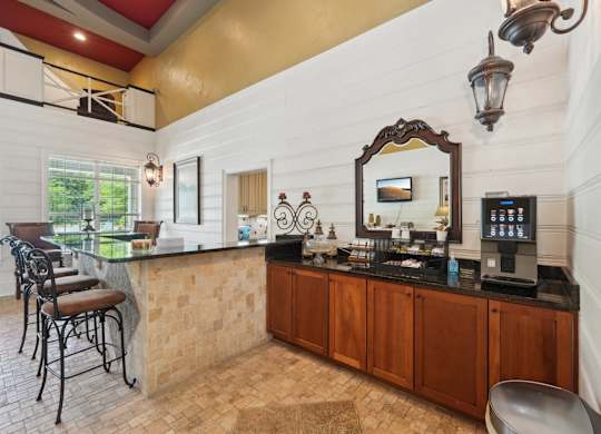 A bar area with stools and a coffee machine station.