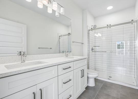 Bathrooms with glass door stand-up showers and double vanity sink