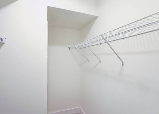 A white closet with a metal racks.