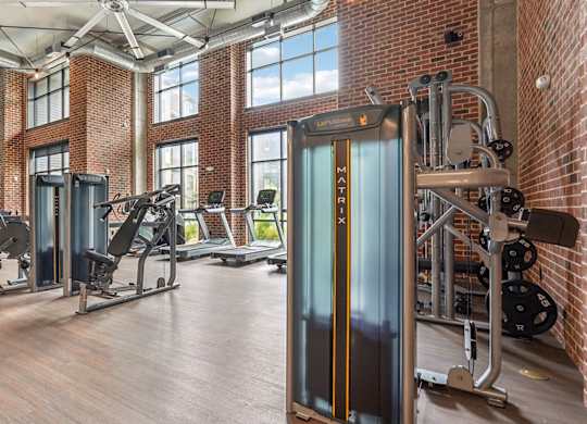 A gym with a variety of equipment including treadmills, weights, and exercise machines.