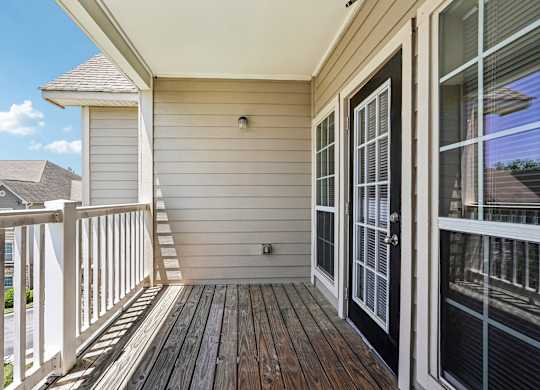A balcony with a black door and a white railing.