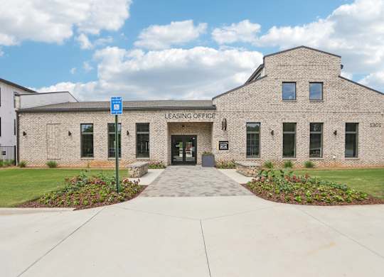 The leasing office and resident clubhouse  with a pool in the background.