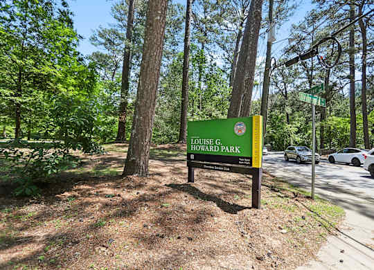 Louise G. Howard Park sign in front of trees.