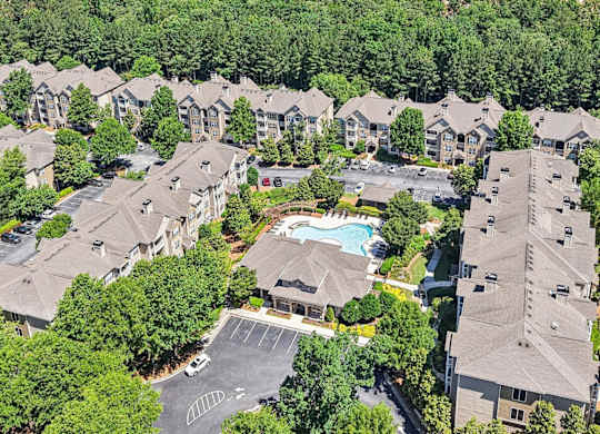 A bird's eye view of a residential complex with a swimming pool.