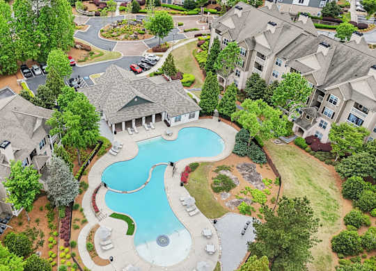 A bird's eye view of a residential area with apartments, and a swimming pool.