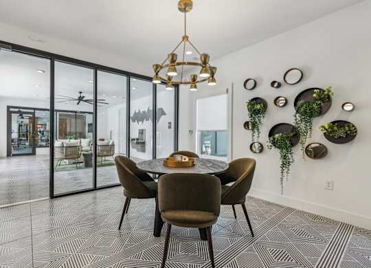 A dining room with a table and chairs and a chandelier.