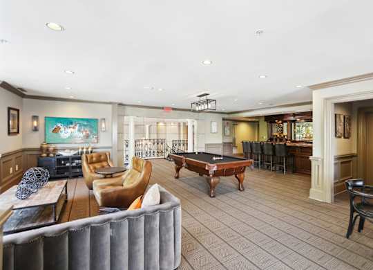Resident Clubhouse: a large room with a pool table and comfortable seating at the bar with a coffee machine