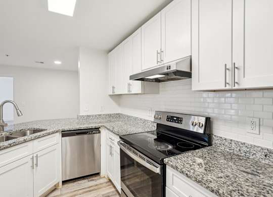 A modern kitchen with granite countertops and stainless steel appliances.