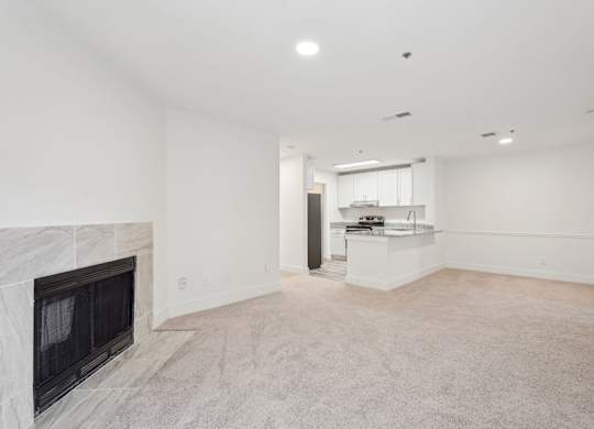 A large living room with fireplace and dining room with view of kitchen