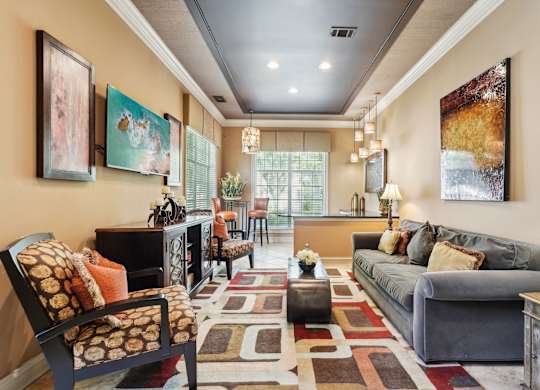 Resident lounge with a TV, couch, chairs, bar area with more seating