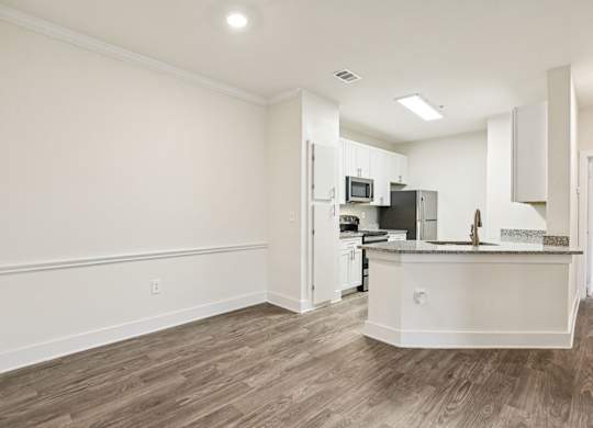 A large dining room area and a renovated kitchen with white cabinets, granite countertops through out and stainless steel appliances