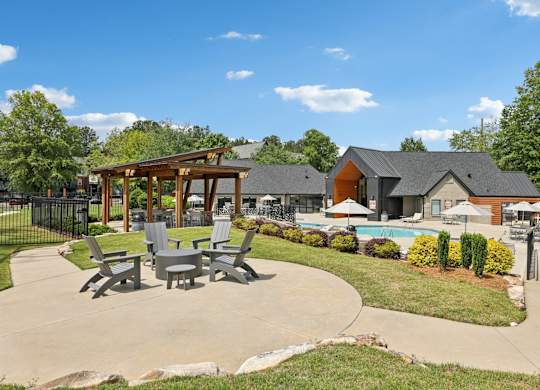 A sunny day at a poolside area with a pavilion and chairs.