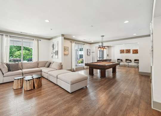 Resident clubhouse with couch, billiards, shuffle board and seating