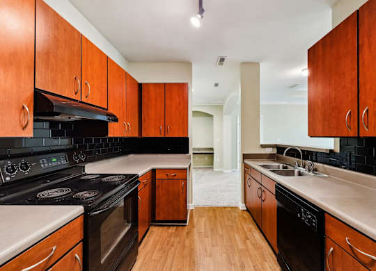 A kitchen with wooden cabinets and black appliances.