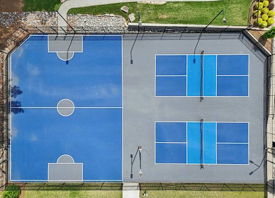 A tennis court with blue surface and white lines.