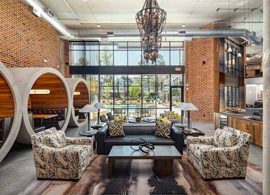 Resident clubhouse with many seating areas with couches, work booths, and chairs