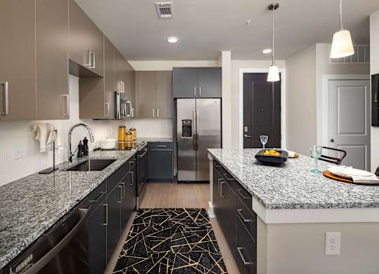 A modern kitchen with granite countertops and stainless steel appliances.