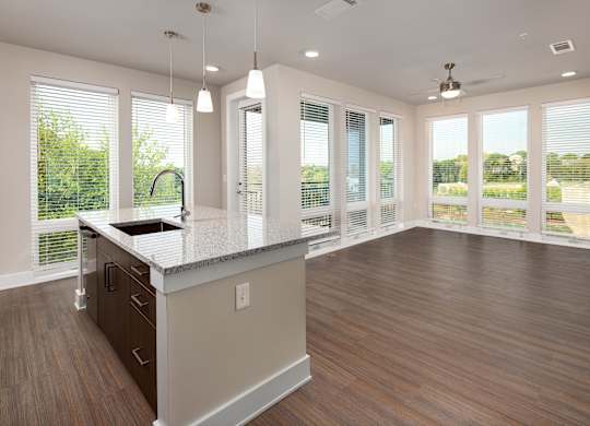 A modern kitchen with stainless steel appliances and floor to ceiling windows
