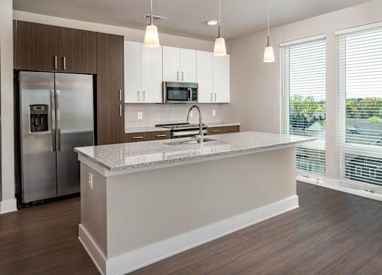 A modern kitchen with wooden floors and white and brown wood cabinets with stainless steel appliances