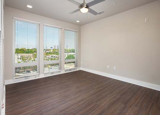 A bedroom with a ceiling fan and  floor-to-ceiling windows