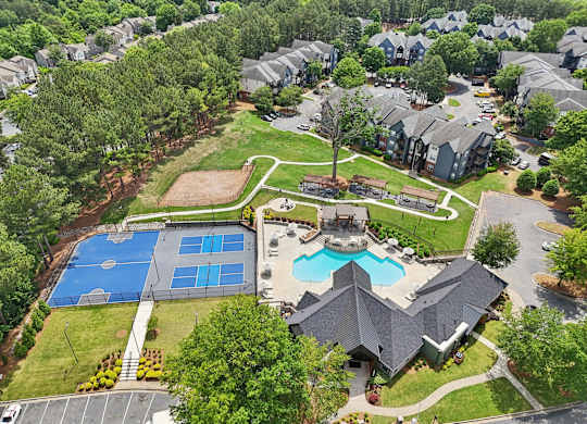 A bird's eye view of a residential area with a swimming pool and tennis court.