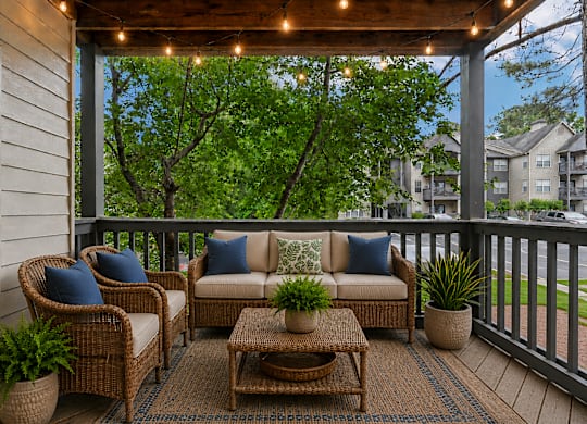 A patio with a couch, chairs, and a coffee table.