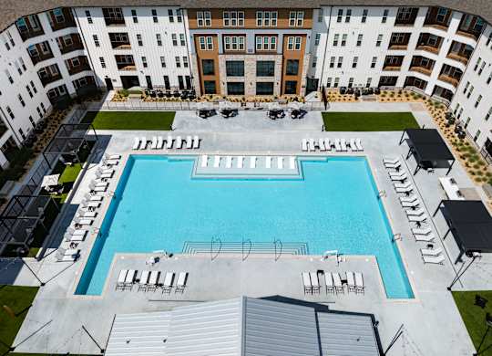 A large swimming pool surrounded by apartment buildings. the largest pool in douglasville georgia.