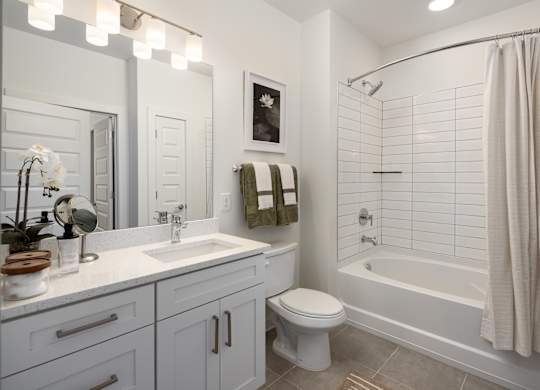 A white bathroom with a toilet, sink, and bathtub.