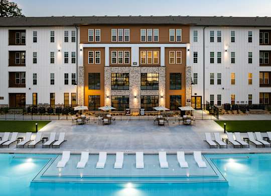 A large building with a pool in front of it.