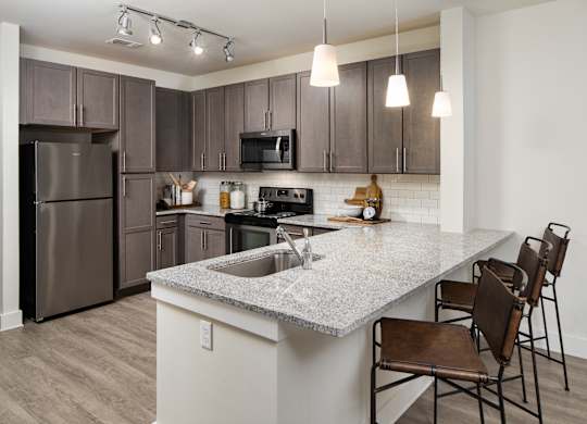 A modern kitchen with wooden cabinets and a granite countertops
