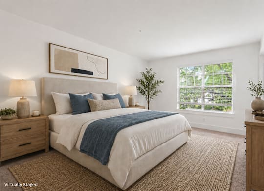 A bedroom with a large bed, a nightstand, and a mirror.