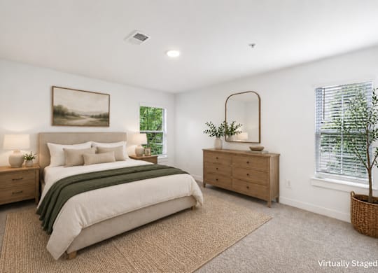 A bedroom with a bed, nightstands, and a plant.