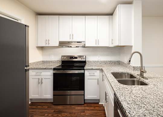 A kitchen with a granite countertop and stainless steel appliances.