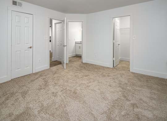 A bedroom with carpeted floor, bathroom and walk-in closet