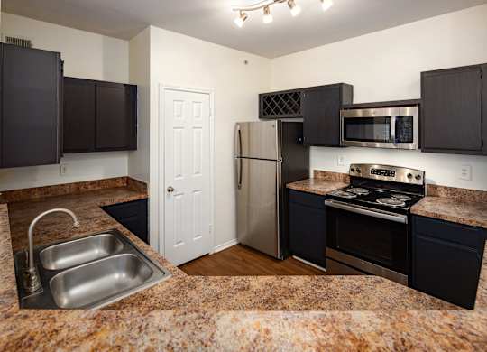 A classic style  kitchen with black cabinets  and stainless steel appliances