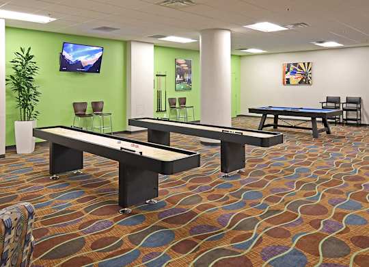 A room with a pool table and a TV on the wall.