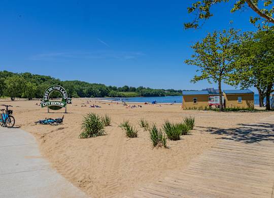 A beach scene with a bicycle parked on the sand.