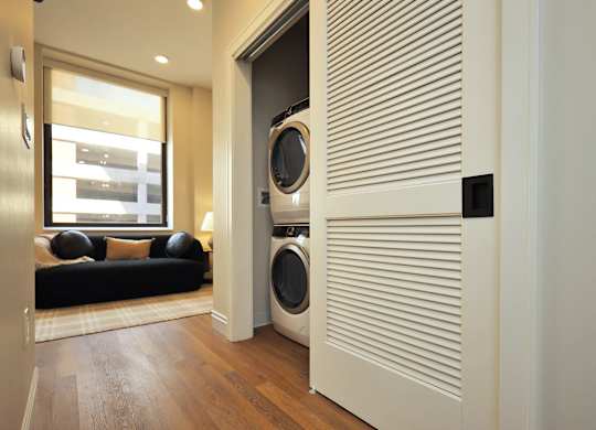 A modern laundry room with a washer and dryer built into a wall.