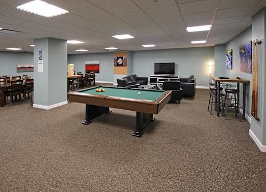 A room with a pool table and a TV.