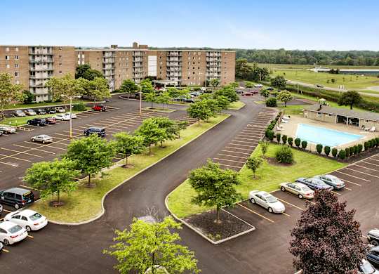 A parking lot with cars and apartment buildings in the background.