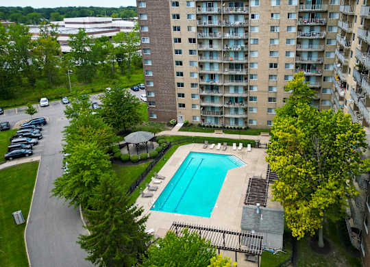 outdoor swimming pool and sundeck surrounded by trees at Willoughby Hills Towers Apartments, Willoughby Hills, OH 44092