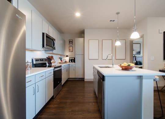 a kitchen with a large island and a stainless steel refrigerator at Parkside at Littleton Village, Littleton, CO