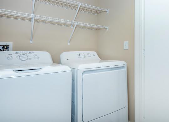 Two white front loading washing machines in a laundry room.
