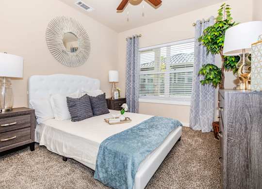 A bedroom with a white bed and a blue blanket.