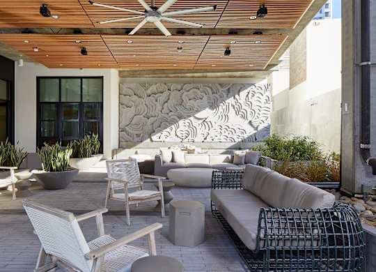 A patio with a white chair and a white couch.