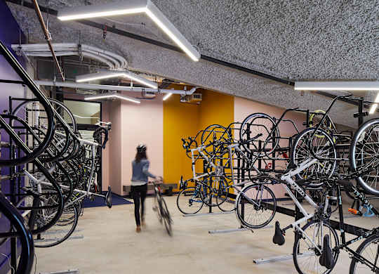 A person walks through a room full of bicycles.