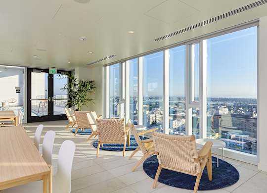 A room with a view of the cityscape through large windows.