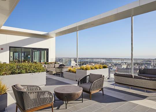 A patio with a table and chairs overlooking a cityscape.