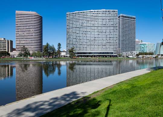 A cityscape with buildings and a body of water in the foreground.