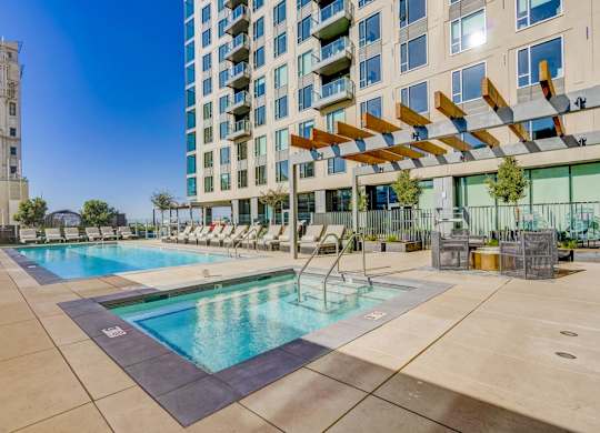 A large swimming pool with a slide in front of a modern building.